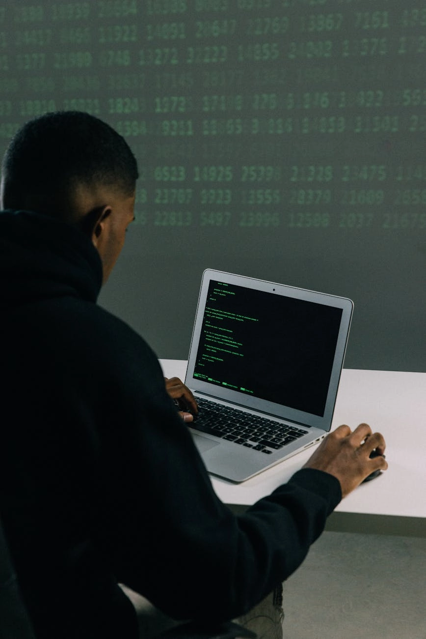 man in black hoodie using macbook air